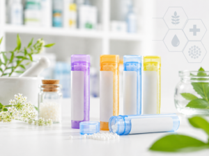 Tubes de granules homéopathiques posés sur un comptoir de pharmacie, fond blanc épuré